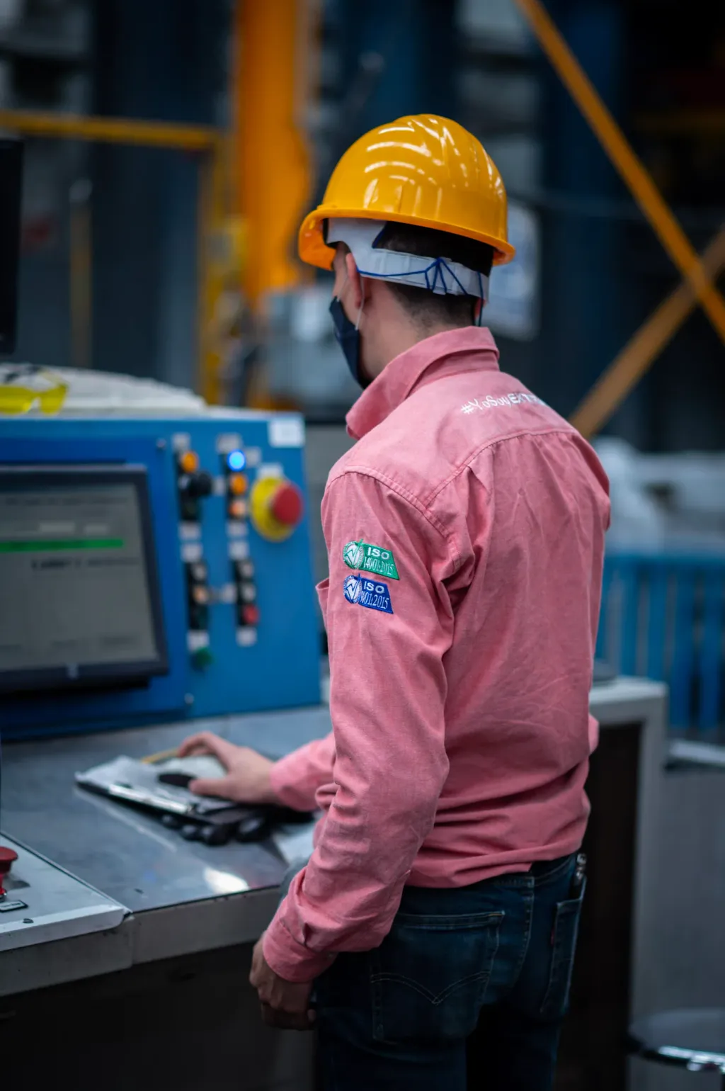Operador de Masi supervisando una estación de control en la planta de extrusión